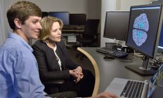 David Jangraw, Ph.D., investigador de los Institutos Nacionales de la Salud (izquierda), revisa una gammagrafía cerebral con Renée Fleming en los NIH. 
