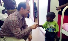 El Dr. Russell E. Ware se reúne con un paciente joven con enfermedad de células falciformes en África. 