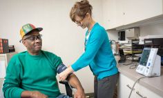 La enfermera Miriam Baird, le toma la presión arterial a Curtis Minor, un participante en un ensayo clínico de los Institutos Nacionales de la Salud.  