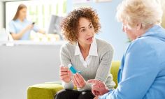 Female doctor explains how to use an inhaler to older patient. 