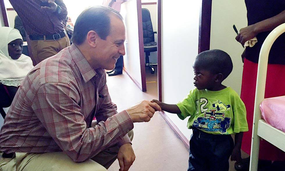 Russell E. Ware M.D., Ph.D., meets with a young sickle cell patient in Africa. 