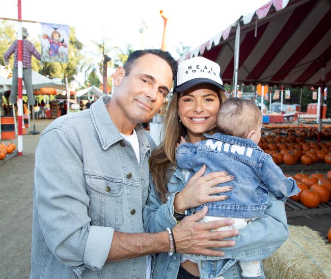 Maria Menounos holding her daughter and standing alongside her husband Keven Undergaro at a pumpkin patch